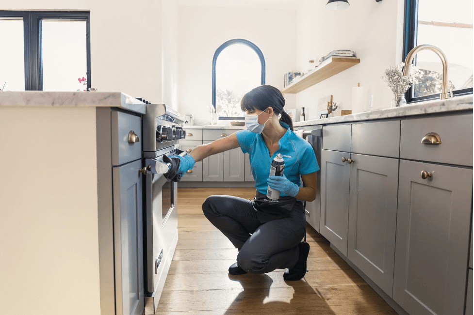 A Merry Maids team member scrubbing down an oven’s exterior during house cleaning service in Decatur, Georgia