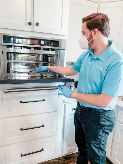 Merry Maids team member cleaning the inside of an oven