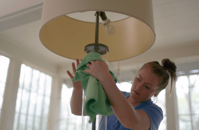 Merry Maids of Locust Grove team member cleaning a lamp