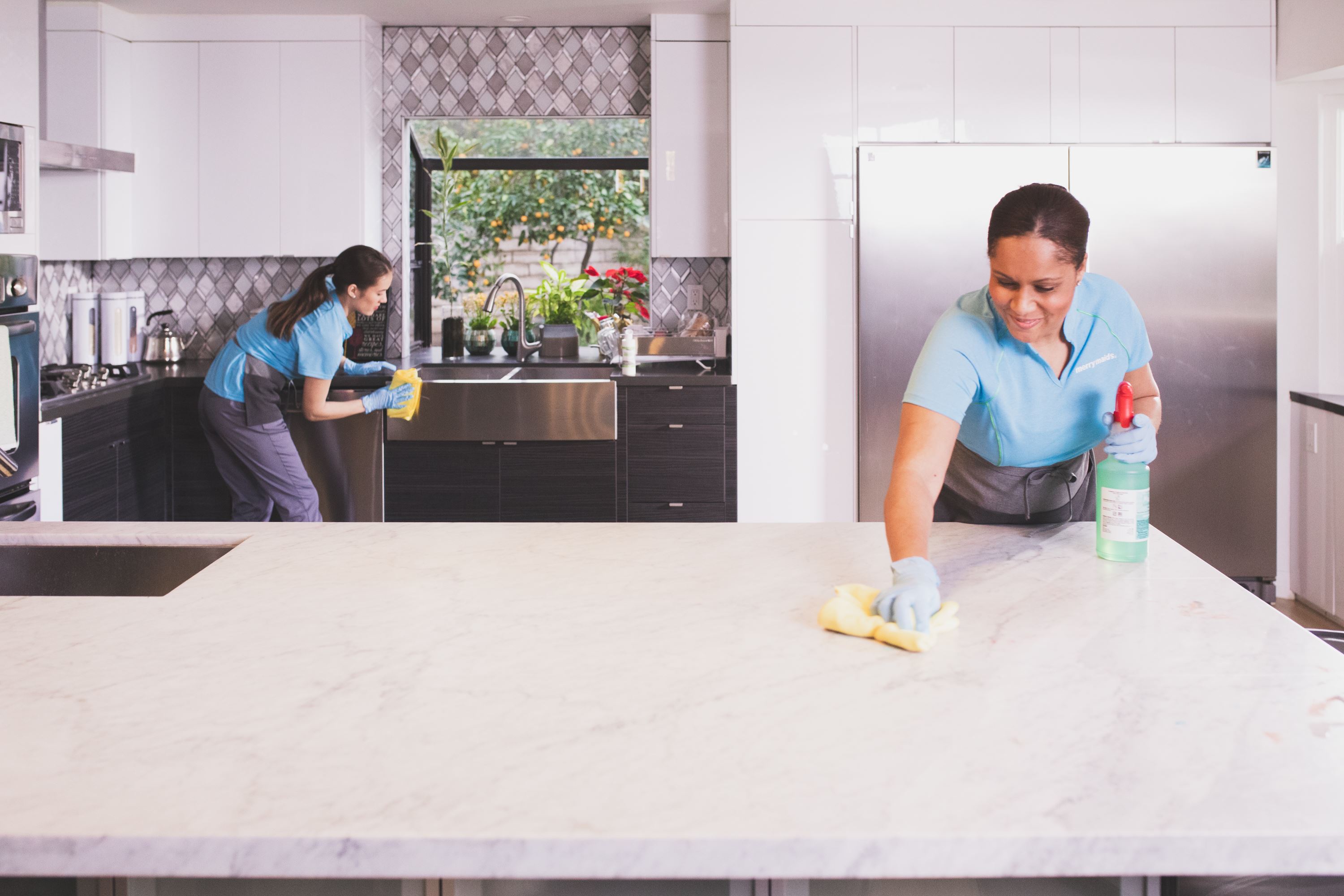 Merry Maids team members disinfecting during maid service