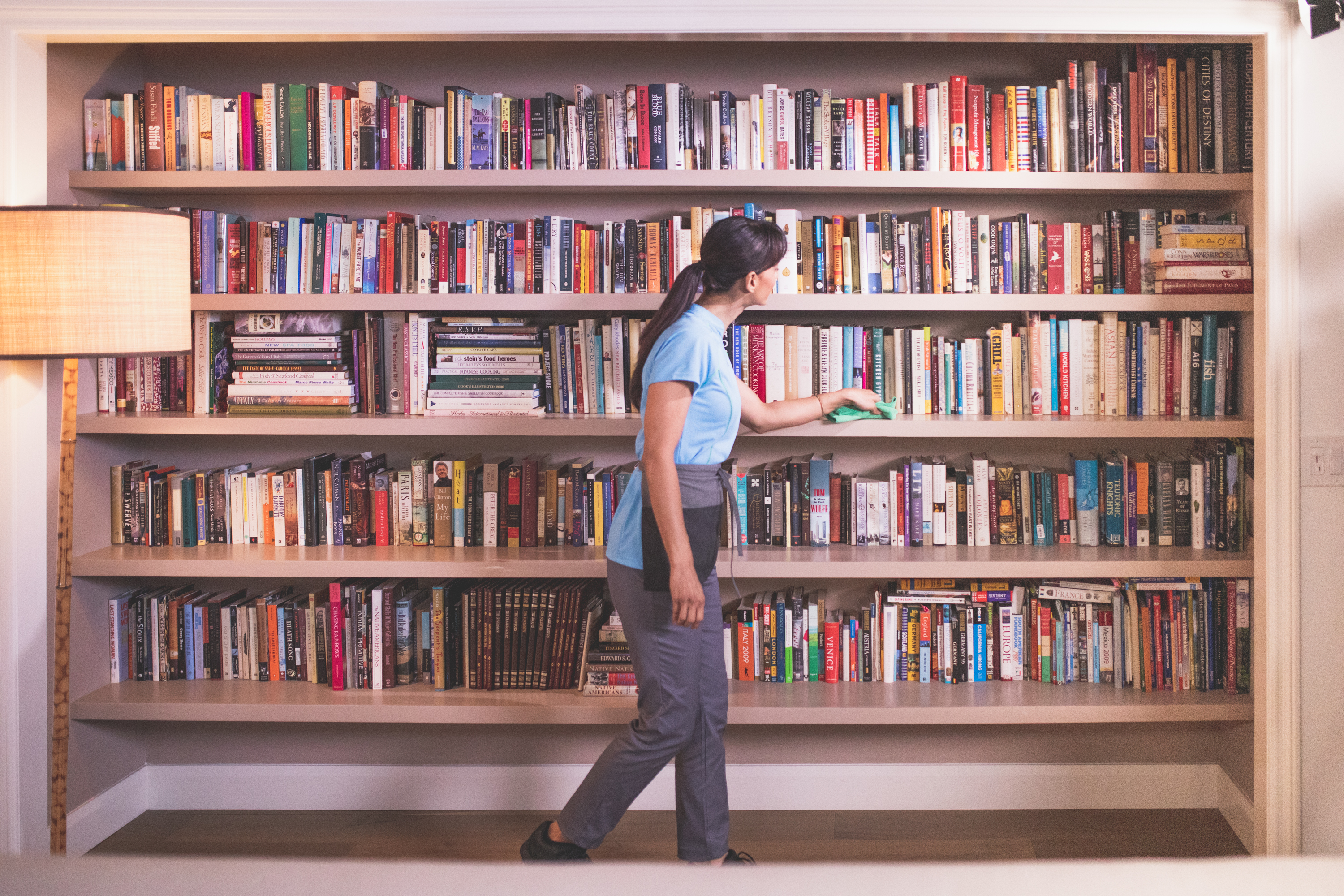 A Merry Maids team member wiping down a bookshelf during deep cleaning services in St. Augustine, Florida