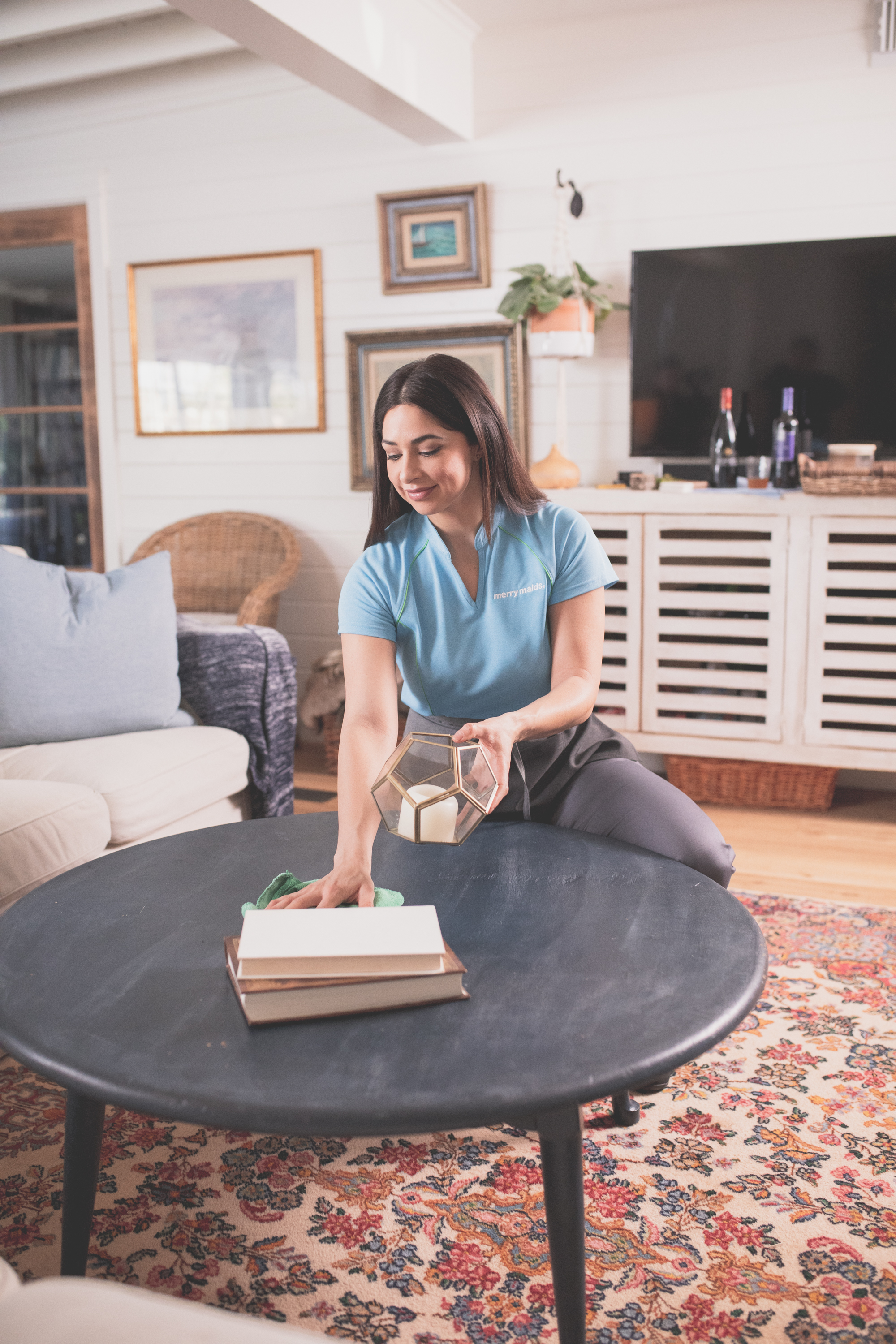  A Merry Maids expert wiping down a coffee table during maid service in Waco, TX