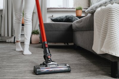 A woman vacuuming a carpeted floor