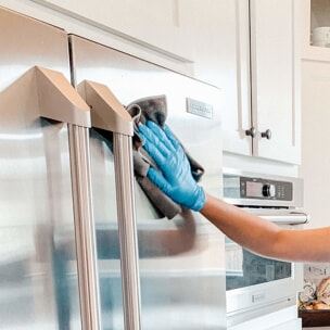 Professional move out cleaner wiping exterior of fridge