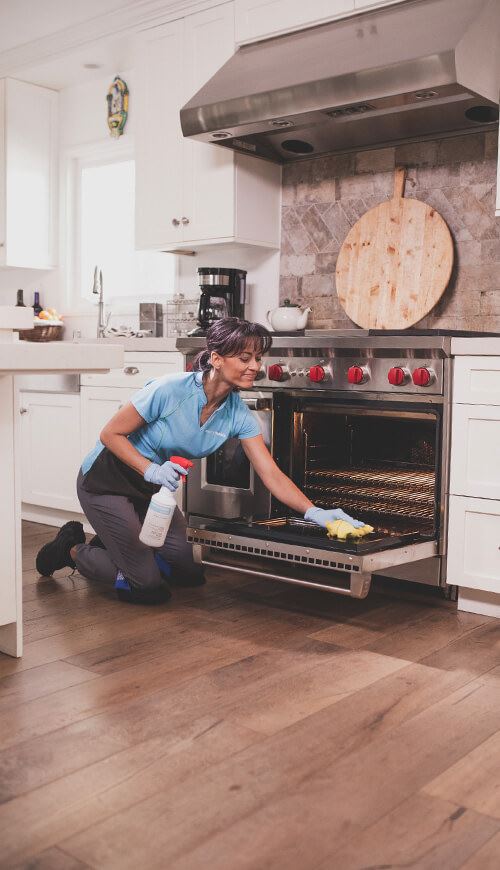 Maid cleaning oven